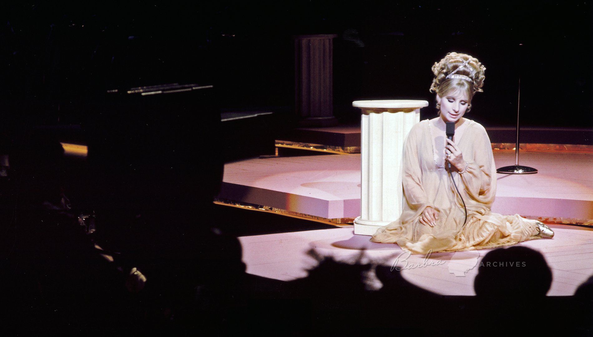 Streisand sitting on the stage and singing a song at the International Hotel