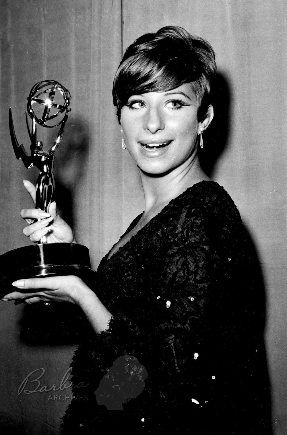 Streisand holding her Emmy award.