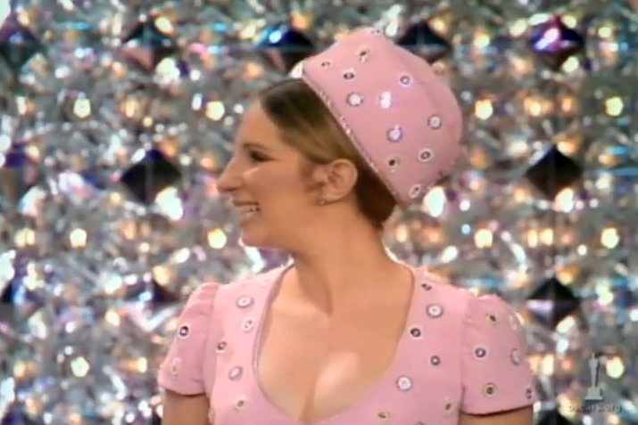 Streisand, wearing pink Scaasi, gives Oscar to John Wayne.