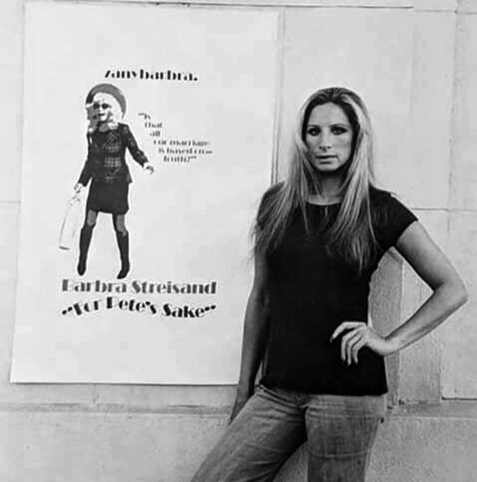 Streisand poses next to a poster for her movie.