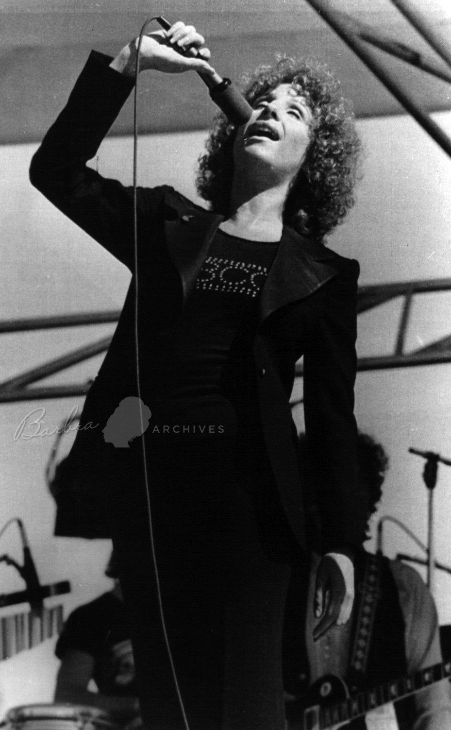 Streisand in black jacket on Arizona stage.