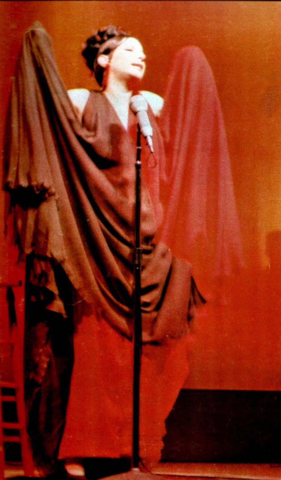 Streisand at microphone in layered chiffon gown
