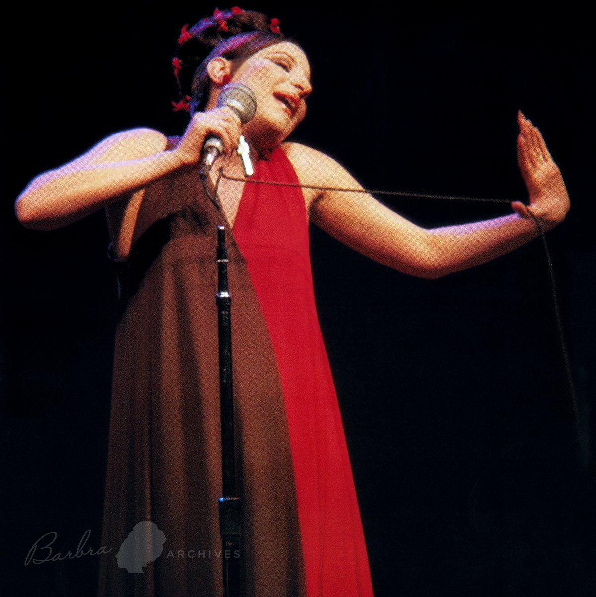 Barbra Streisand in split-colored dress with the microphone in Philadelphia.