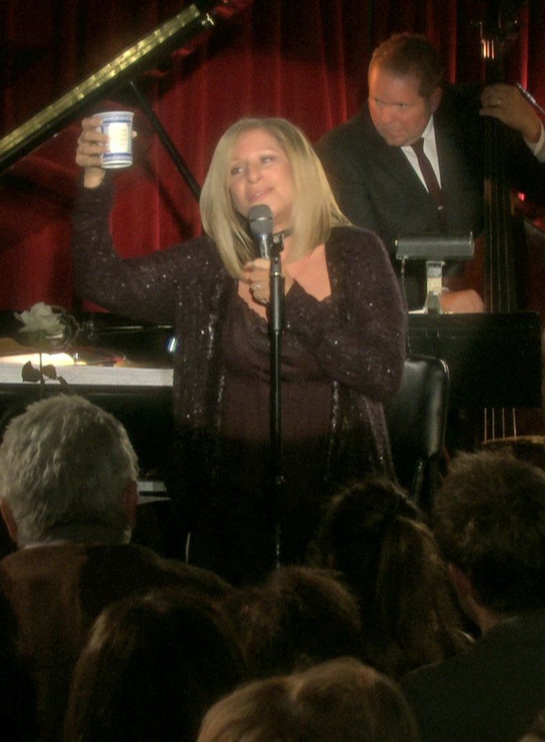 Streisand toasts the audience with a cup at the end of her first song at the Village Vanguard.