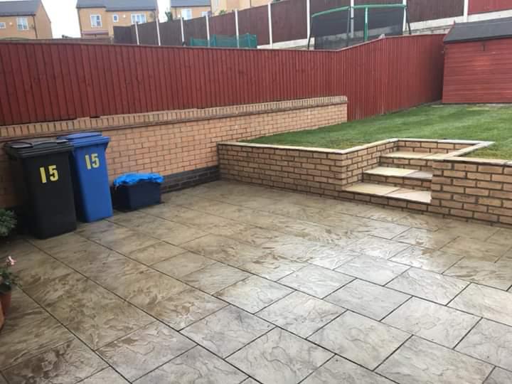 Paving Leeds Sandstone patio with retaining wall and steps to lawn area