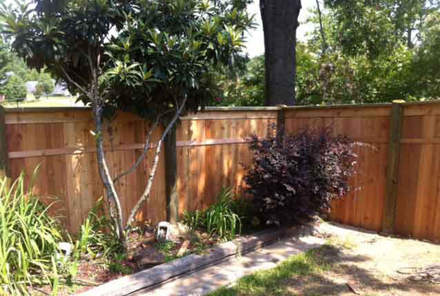 wooden privacy fence next to flower bed