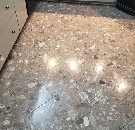 A close up of a shiny tiled floor in a kitchen.