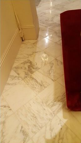 A marble floor with a red chair in the background.