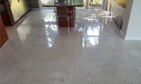 A dining room with a marble floor and a table and chairs.