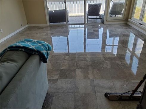 A living room with a couch and a vacuum cleaner on the floor.