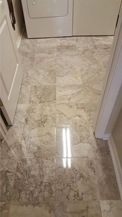 A marble floor in a laundry room with a washer and dryer.