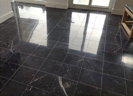 A room with a black tile floor and a wooden table.