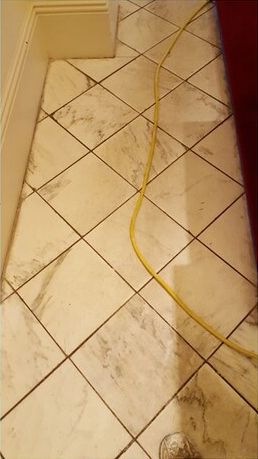 A close up of a tiled floor with a yellow cord.