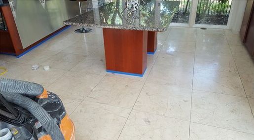 A vacuum cleaner is sitting next to a table in a kitchen.