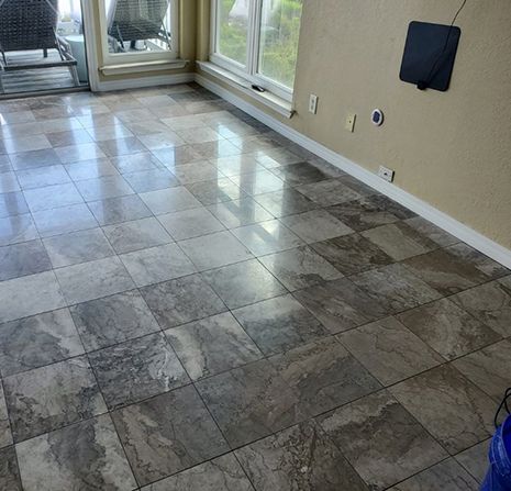 A living room with a tiled floor and a window.