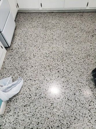 A kitchen floor with a lot of small stones on it.