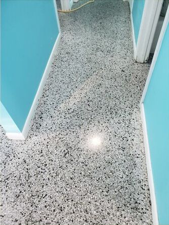 A hallway with a concrete floor and blue walls.