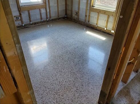 A room with a concrete floor and a wooden wall.