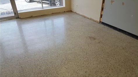 A room with a shiny concrete floor and a window.