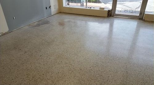 A room with a shiny concrete floor and a window.