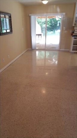 An empty living room with a sliding glass door and a window.
