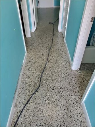 A long hallway with a vacuum cleaner on the floor.