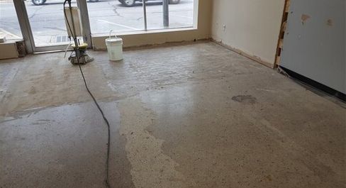 A room with a vacuum cleaner and a bucket on the floor.