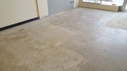 A room with a concrete floor and a white wall.