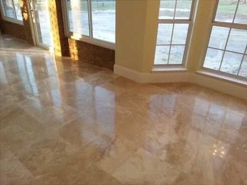 A room with a marble floor and lots of windows