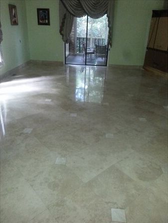 A living room with a marble floor and a sliding glass door.