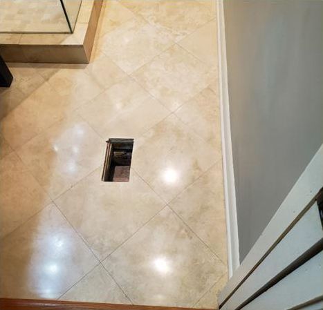 A bathroom floor with a hole in the middle of it.