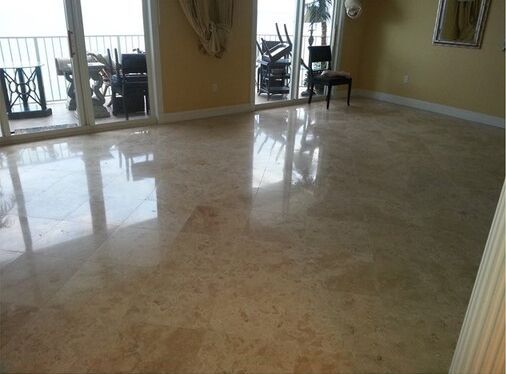 A living room with a marble floor and sliding glass doors