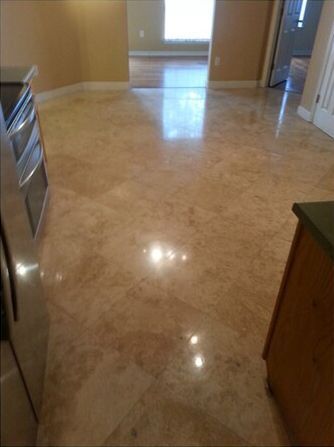 A kitchen with a marble floor and stainless steel appliances.