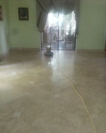 A living room with a vacuum cleaner on the floor and a sliding glass door.