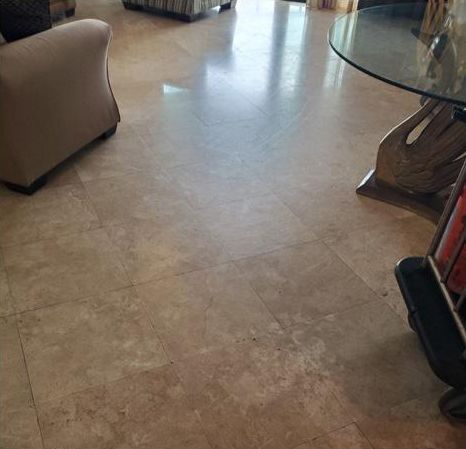 A living room with a glass table and chairs and a tiled floor.