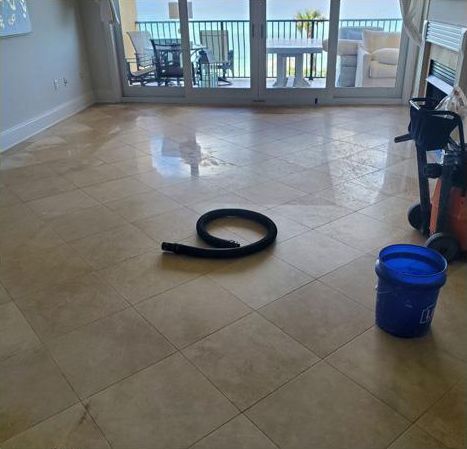 A vacuum cleaner is sitting on a tiled floor next to a blue bucket.
