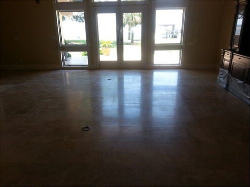 A large empty room with a marble floor and a lot of windows.