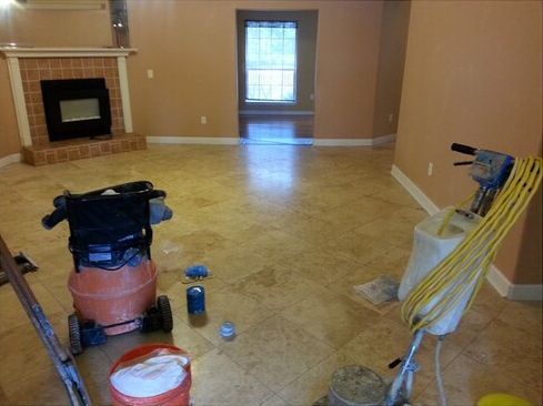An empty living room with a fireplace and a vacuum cleaner