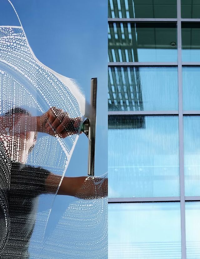 A man is cleaning a window with a squeegee.