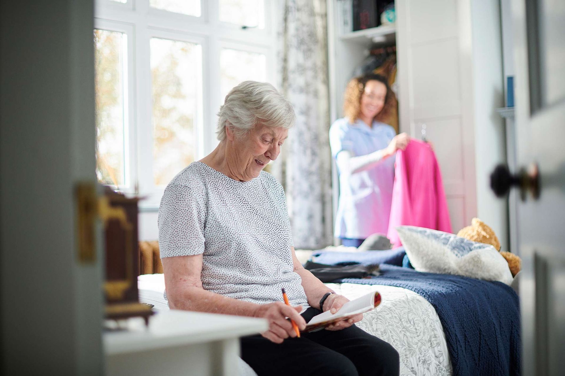 Senior woman holding a pen and smiling | Adelaide, SA | Pristine Support Services