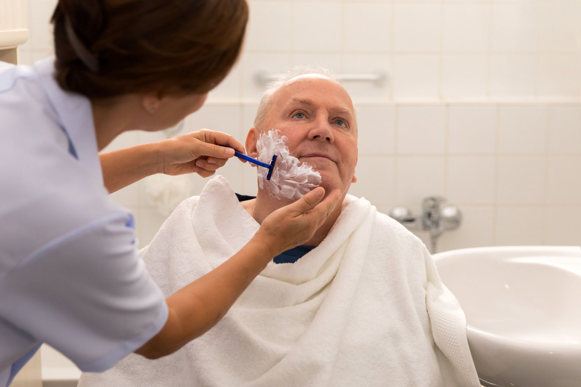 Woman shaving a senior man | Adelaide, SA | Pristine Support Services