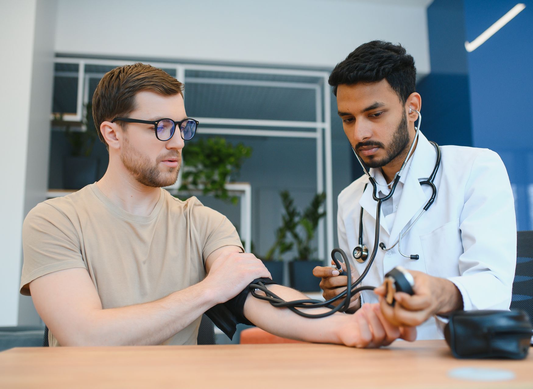 A man getting his  blood pressure taken by a male nurse
