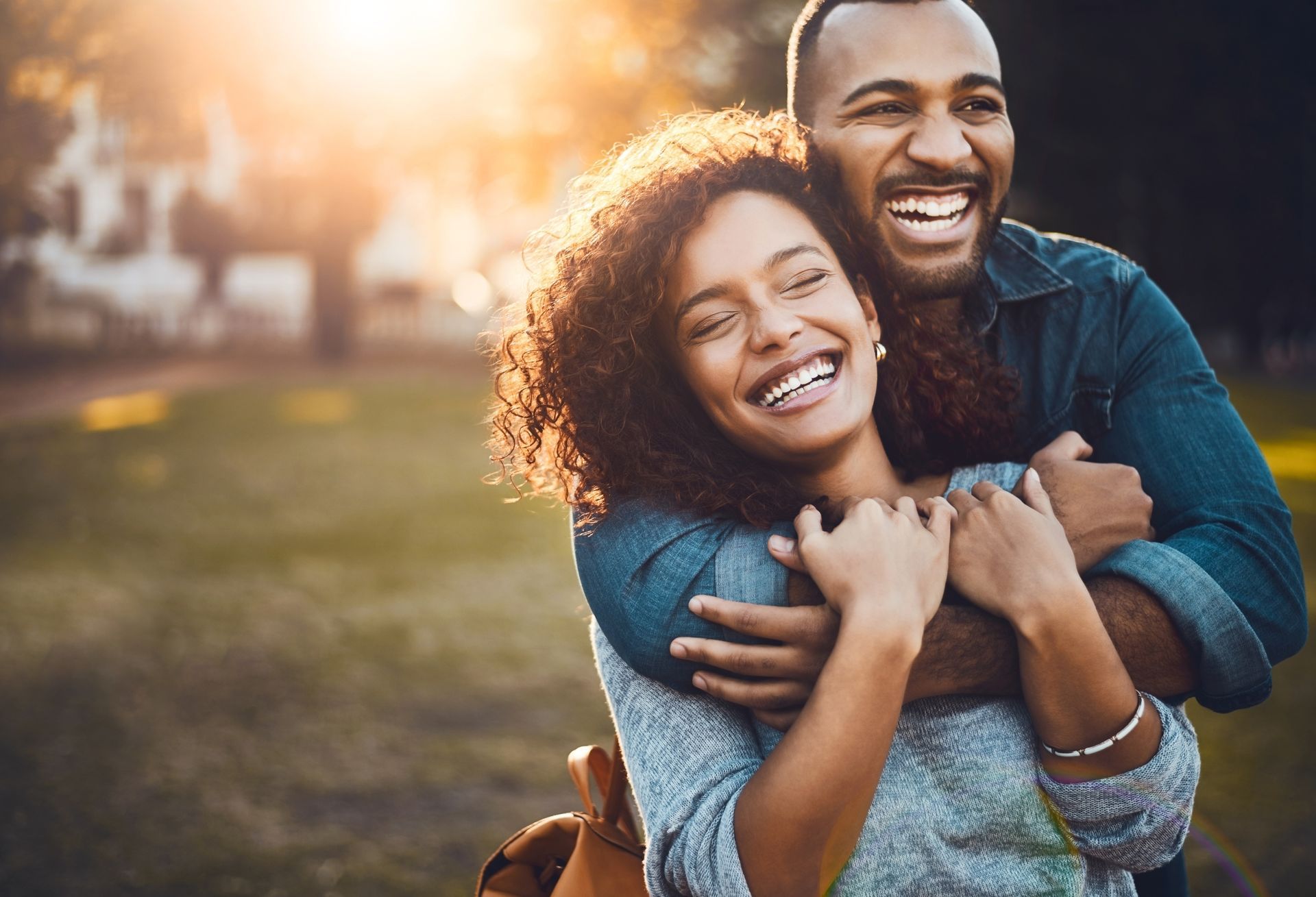 a man is carrying a woman on his back and they are laughing
