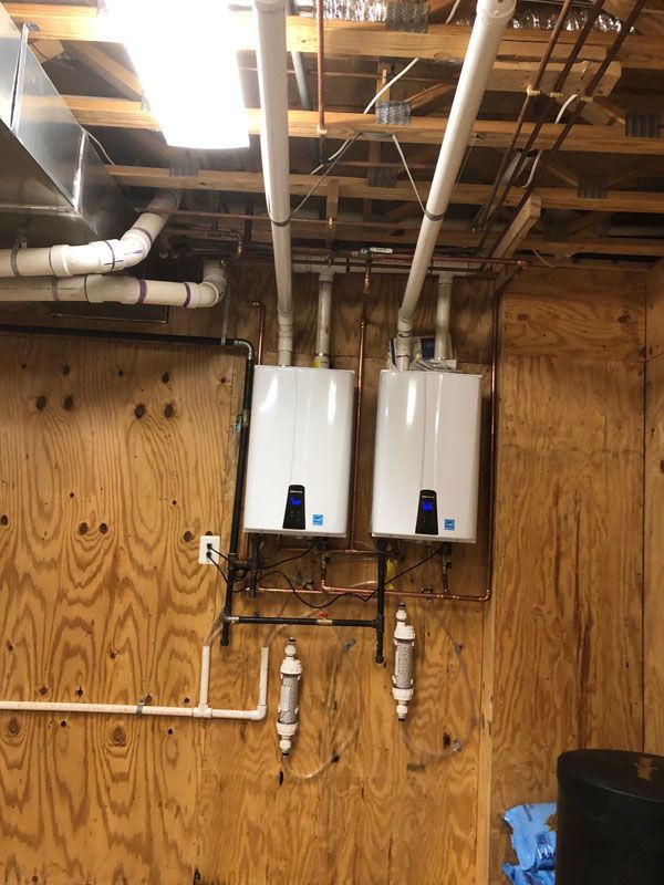 Two Water Heaters Mounted to a Wooden Wall
