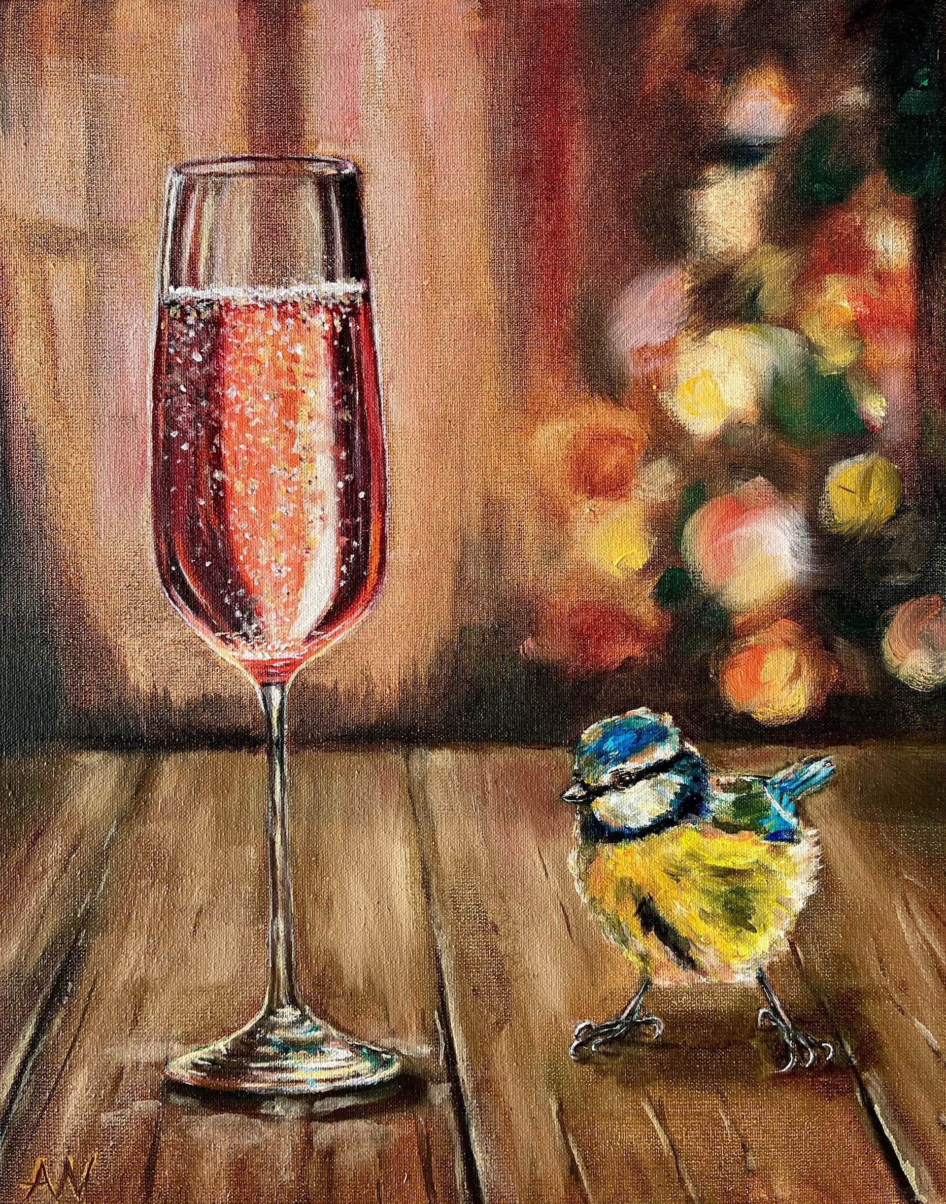 A glass of sparkling pink wine with a small bird on a wooden table, flowers in the background.