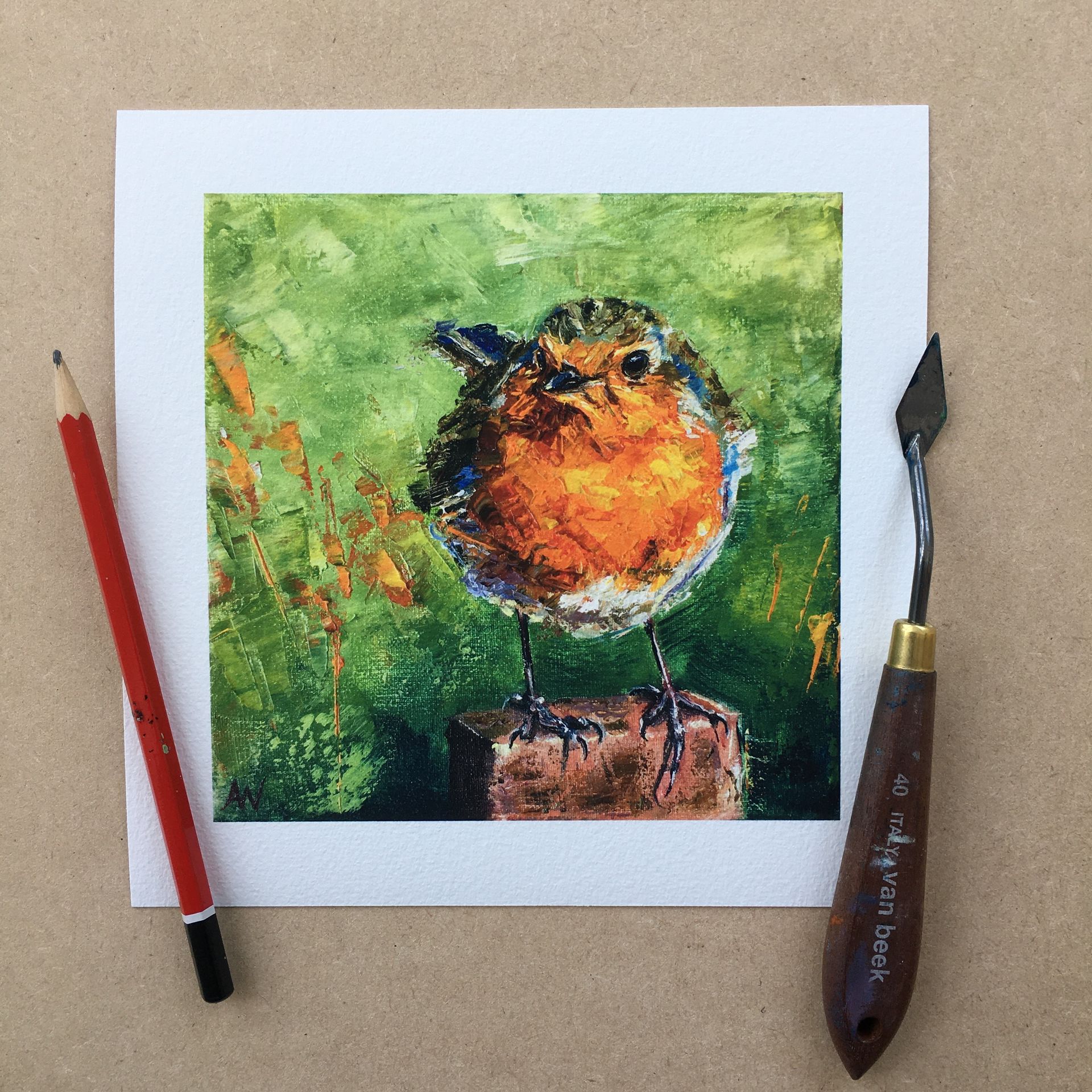 Olieverfschilderij van een roodborstje met oranje borst en groene achtergrond. Ernaast een potlood en paletmes.