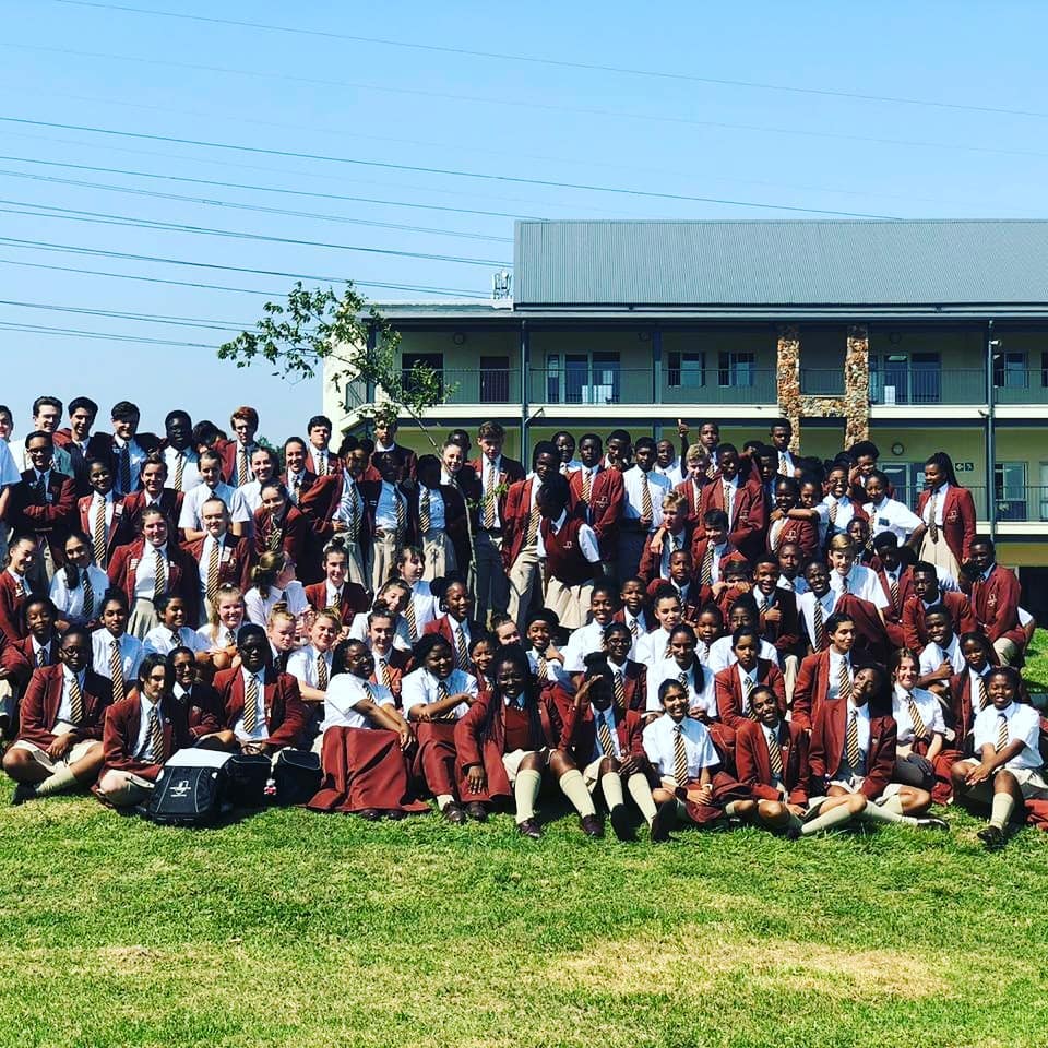 A large group of people are posing for a picture in front of a building