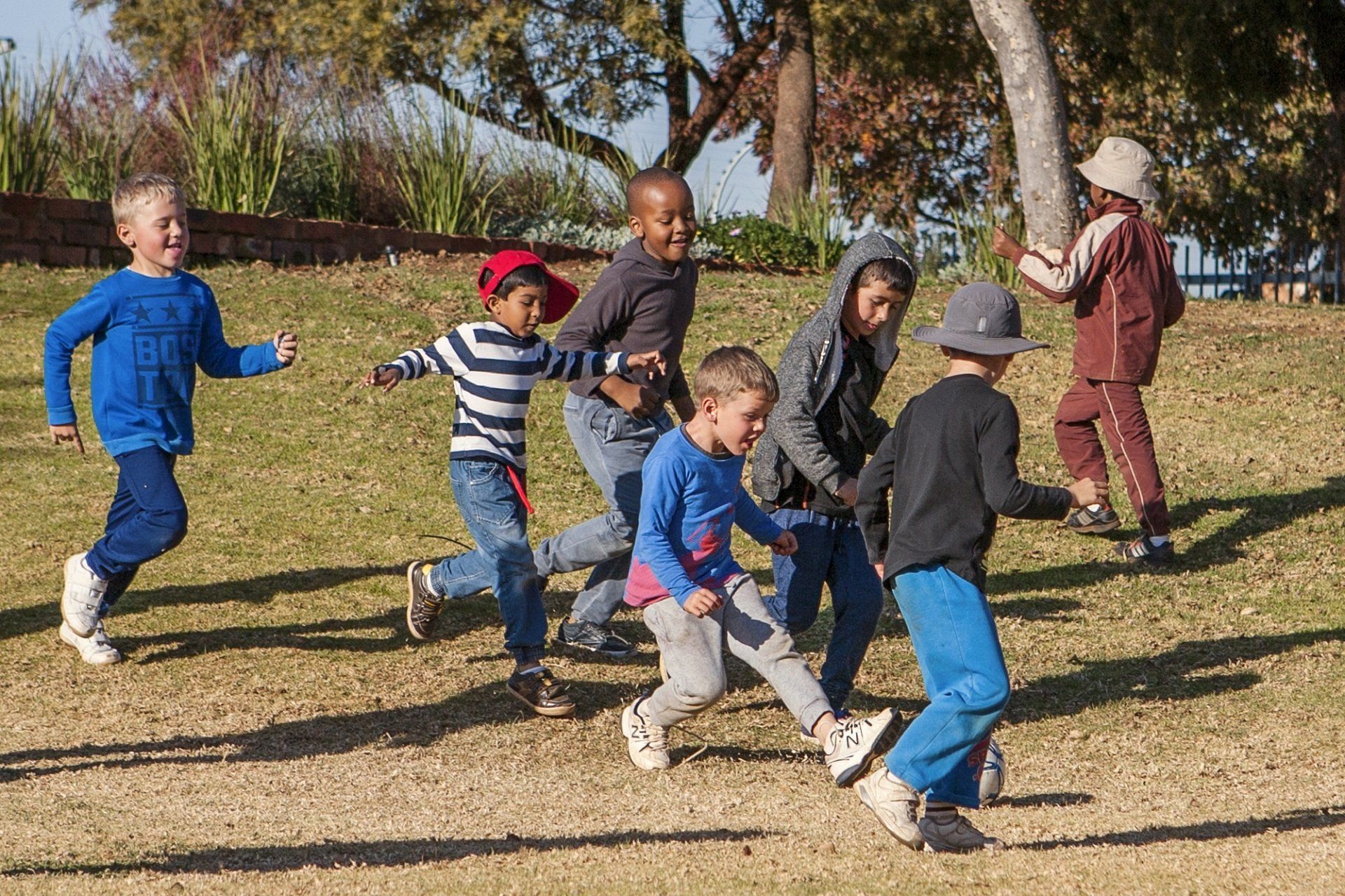 A group of children are running in a field.
