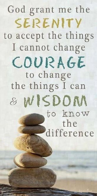 A stack of rocks on a beach with a quote about serenity
