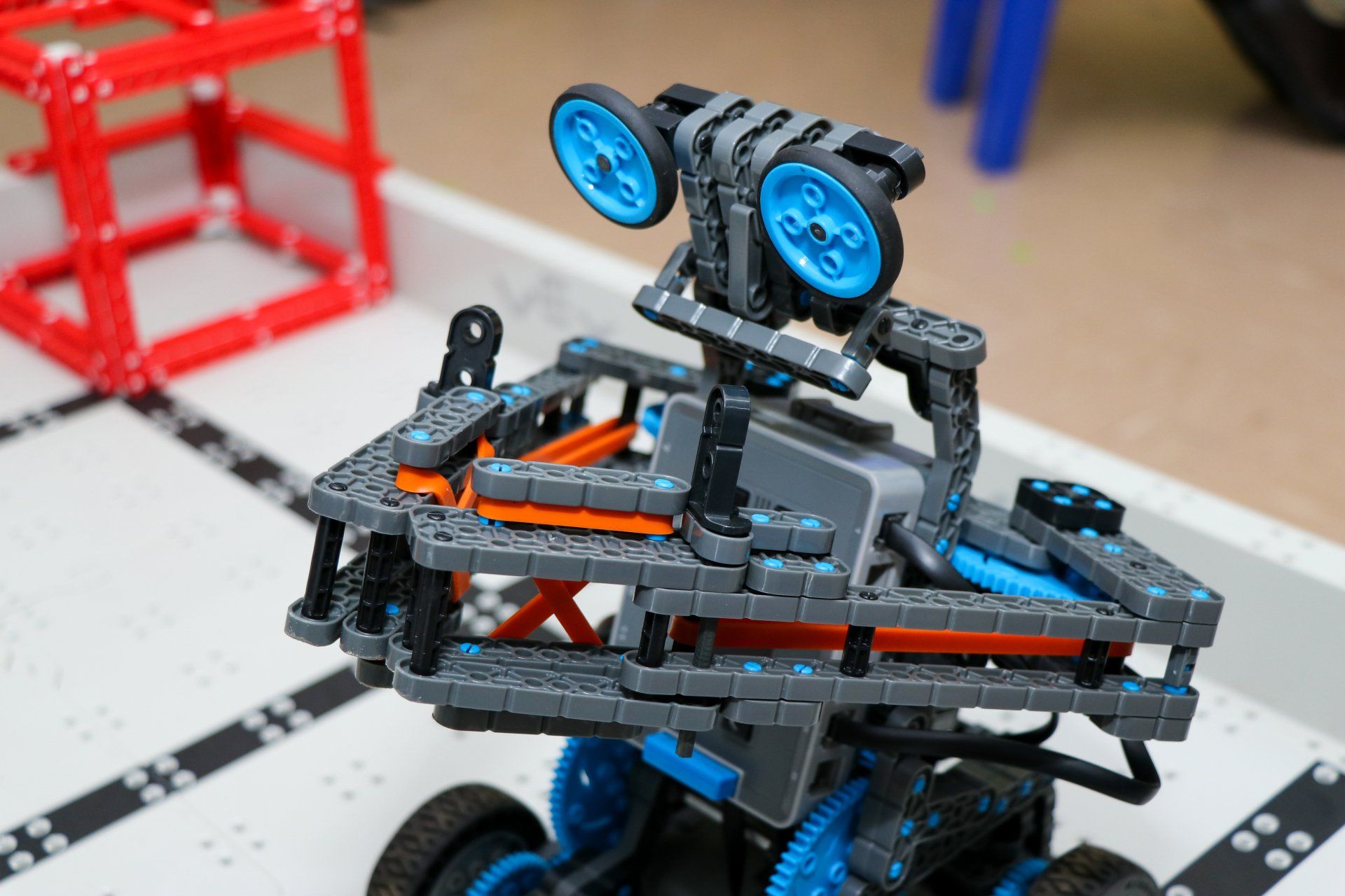 A toy robot is sitting on top of a white table.